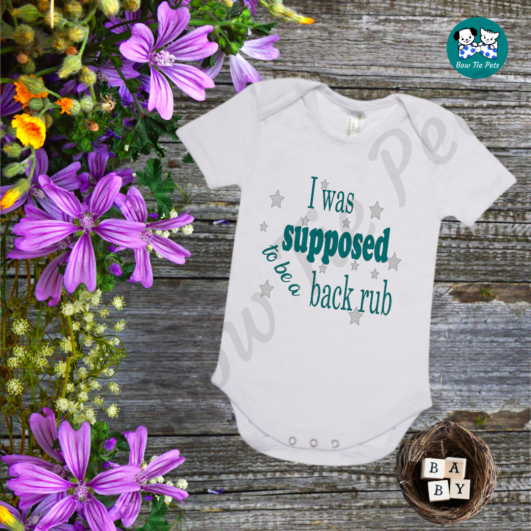 "I was supposed to be a back rub" White romper with teal writing and silver stars