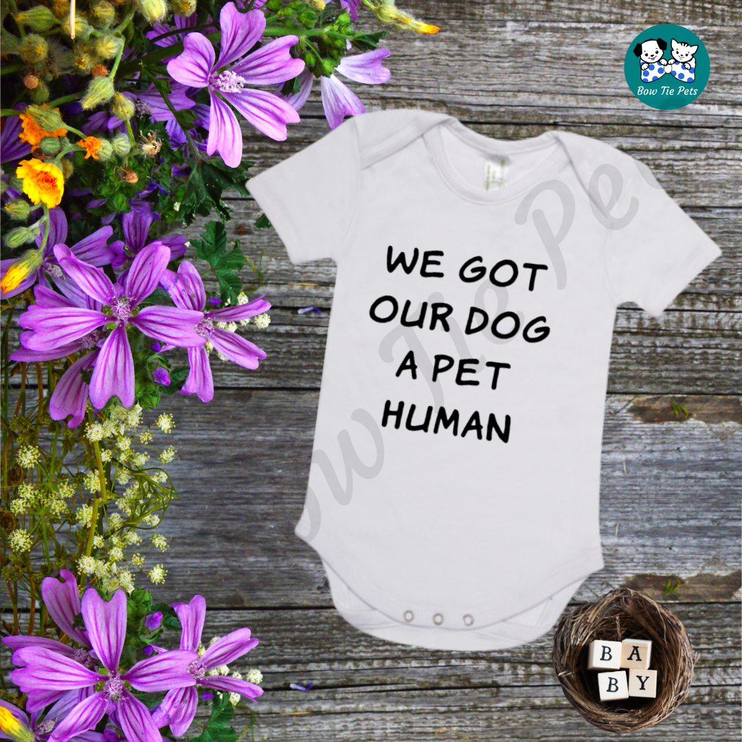 "We got our dog a pet human" White romper with black writing